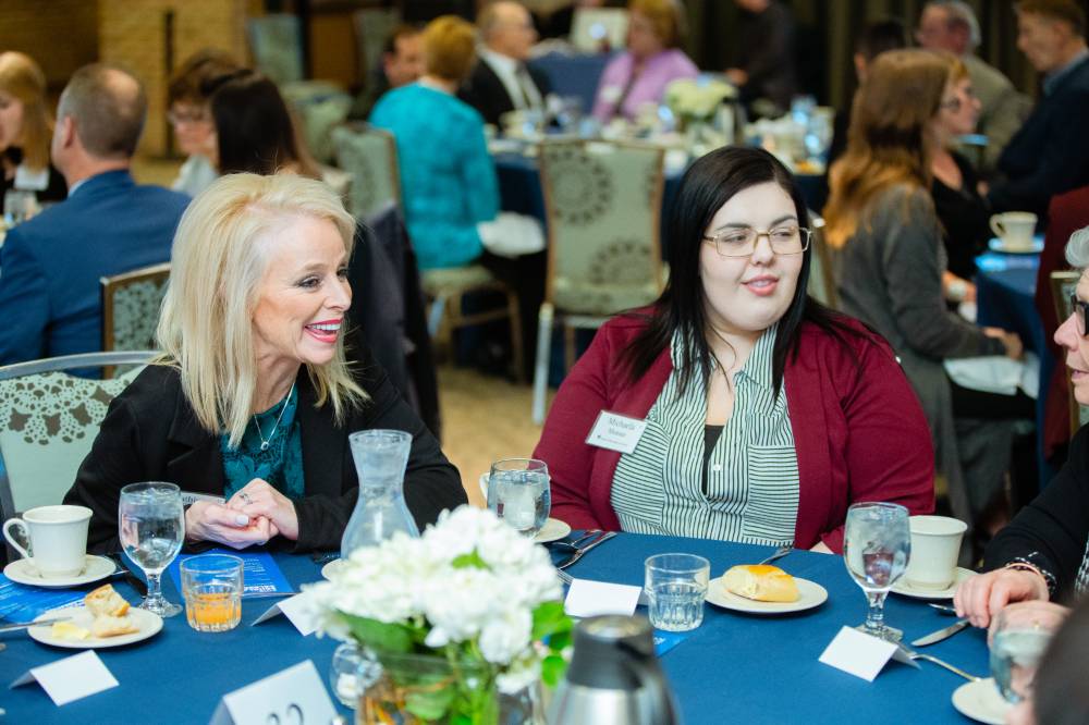 Donor with a student smiling together at a table at Scholarship Dinner 2019